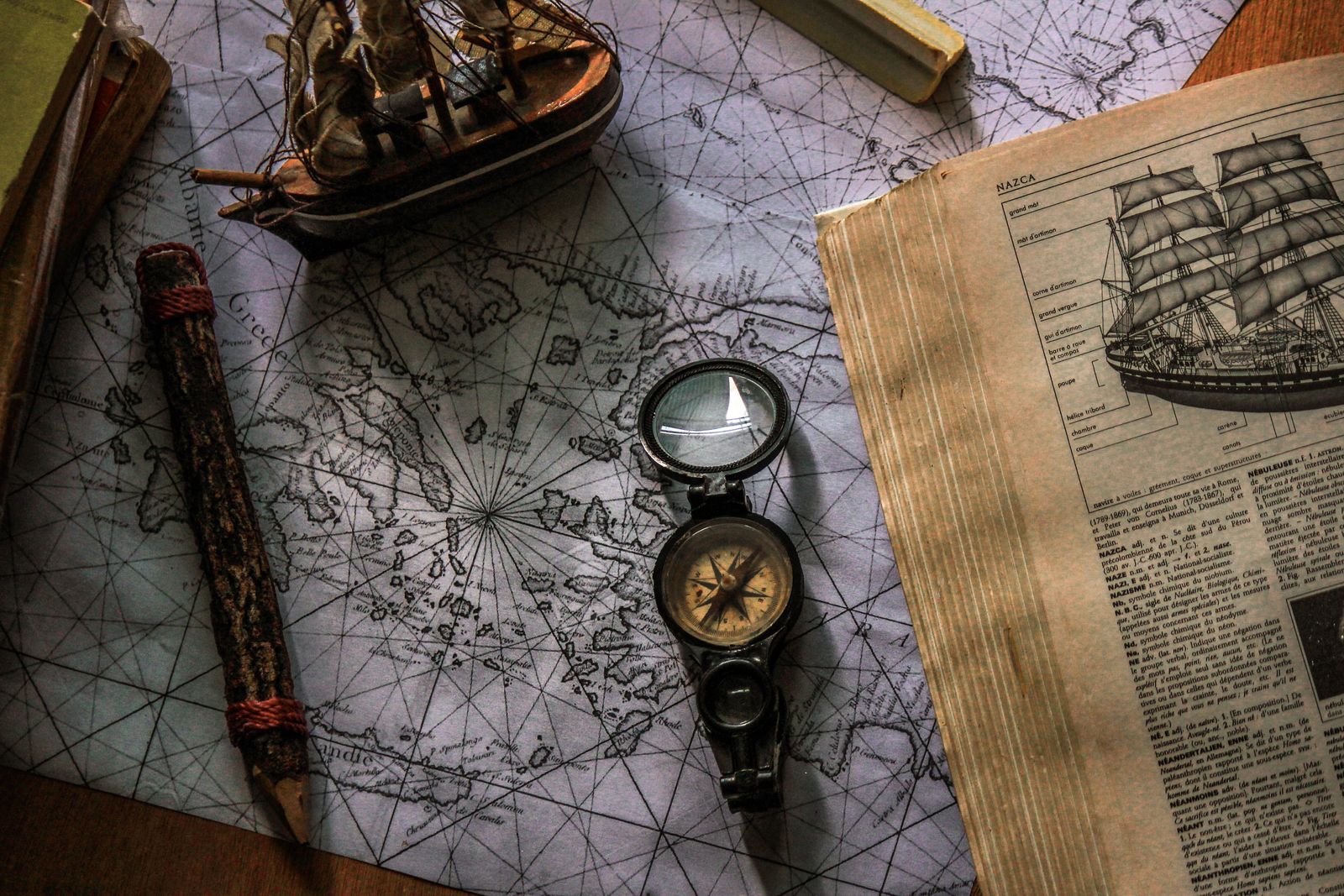A silver compass on an old map