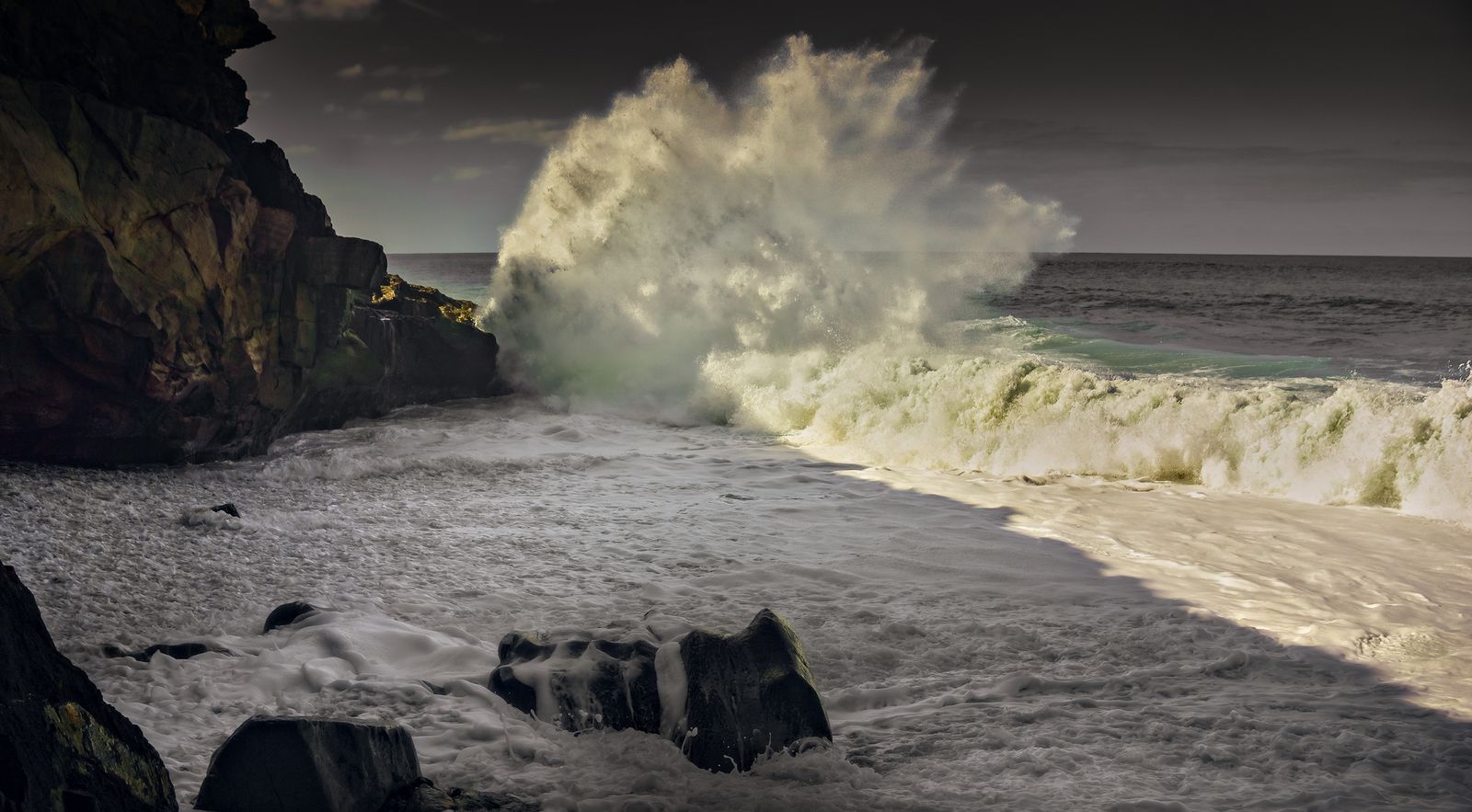 A wave crashing under moonlight